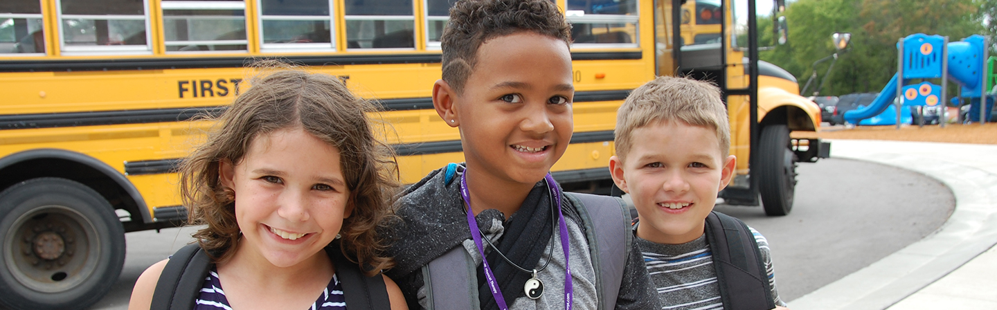 Students in front of the school bus on the first day of school.